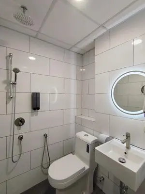 a white bathroom with a toilet and a sink at The great hotel greenhill in Ipoh