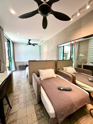 a bedroom with two beds and a ceiling fan at Stylish Villa Alma 18-23 Guests - Pool, KTV & BBQ in Simpang Ampat