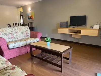 a living room with a pink couch and a table at Brinchang Cameron 2R2B 10 paxs KeaFarm #14402 in Brinchang