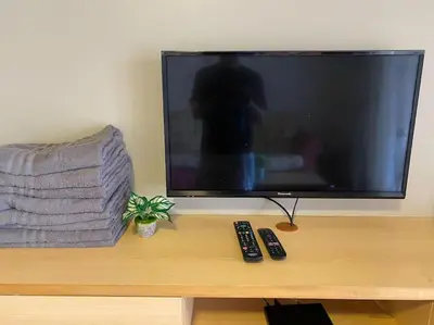 a flat screen tv sitting on a table with two remote controls at Brinchang Cameron 2R2B 10 paxs KeaFarm #14402 in Brinchang