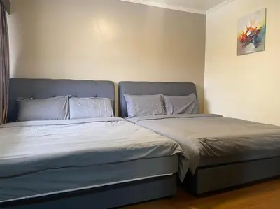 two beds sitting next to each other in a bedroom at Brinchang Cameron 2R2B 10 paxs KeaFarm #14402 in Brinchang