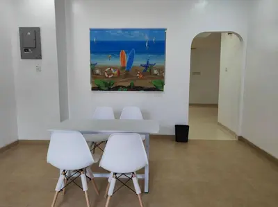 a table with four white chairs and a painting on the wall at Cozy Deluxe House Padang Serai 28pax in Padang Serai