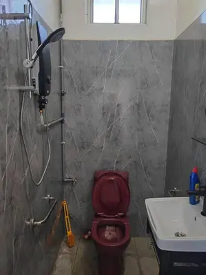a bathroom with a red toilet and a sink at Cozy Deluxe House Padang Serai 28pax in Padang Serai
