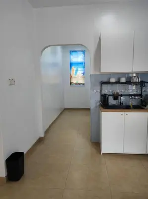 a kitchen with white cabinets and a counter in a room at Cozy Deluxe House Padang Serai 28pax in Padang Serai
