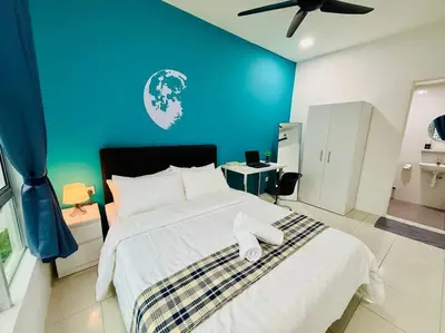 a bedroom with a large bed with a blue wall at Ipoh Midtown Anderson Suite 2R2B in Ipoh