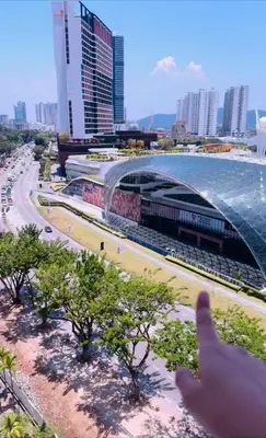 a person giving a thumbs up in front of a stadium at Spc Arena Apartment Service in Bayan Lepas