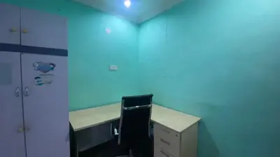 an office with a blue wall and a desk with a chair at Srinibong hotel apartment in Nibung Tebal