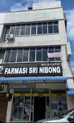 a store with a sign on the front of a building at Srinibong hotel apartment in Nibung Tebal
