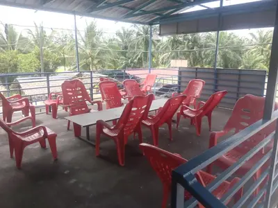 a group of red chairs and a table and chairs at Dalya's Roomstay in Tanjung Karang