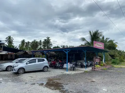 a car parked in front of a restaurant with people sitting at tables at Dalya's Roomstay in Tanjung Karang