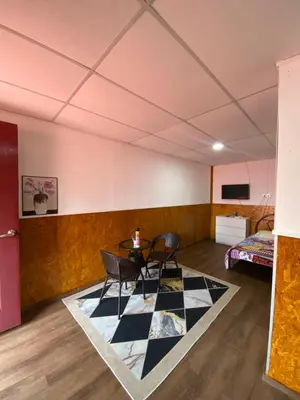a room with two chairs and a table and a bed at Dalya's Roomstay in Tanjung Karang