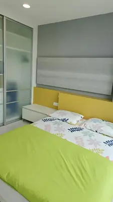 a bedroom with a large bed with a yellow headboard at Straits Garden Suites Georgetown Penang 1BRcondo in George Town