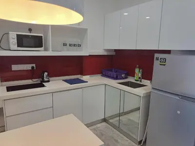 a kitchen with white cabinets and a white refrigerator at 1BR Condo Straits Garden Suites Georgetown Penang in George Town