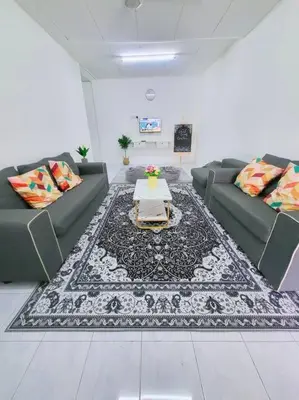 a living room with couches and a table on a rug at CASA AIRA Cozy & Comfy Home in Kampong Kepayang