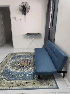 a blue chair in a room with a rug and a fan at CASA AIRA Cozy & Comfy Home in Kampong Kepayang