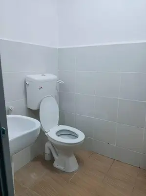 a bathroom with a toilet and a bath tub at CASA AIRA Cozy & Comfy Home in Kampong Kepayang