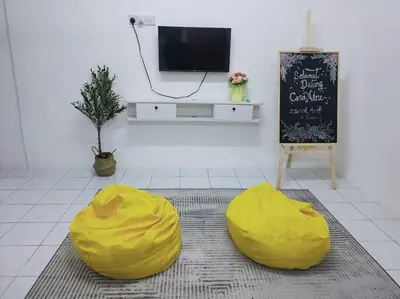 a living room with two yellow bean bags in front of a tv at CASA AIRA Cozy & Comfy Home in Kampong Kepayang