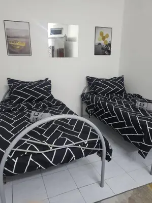 a bedroom with a bed with black and white pillows at CASA AIRA Cozy & Comfy Home in Kampong Kepayang