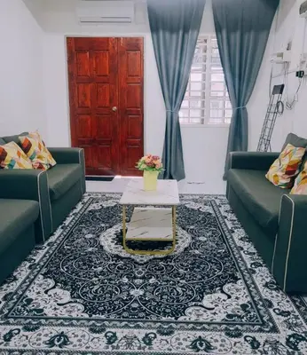 a living room with two green couches and a table at CASA AIRA Cozy & Comfy Home in Kampong Kepayang