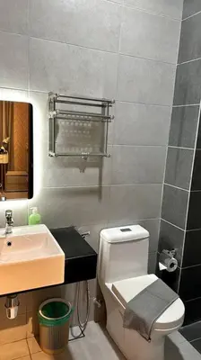 a bathroom with a white toilet and a sink at Urban Emerald Seaview 6Pax 3Queen 3Room 2Bath 2Carpark with Infinity Pool in Jelutong