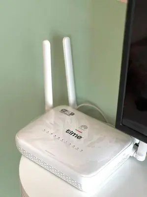 a white router sitting on a table next to a monitor at Urban Emerald Seaview 6Pax 3Queen 3Room 2Bath 2Carpark with Infinity Pool in Jelutong