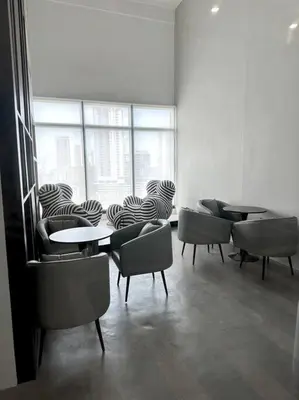 a room with tables and chairs and a large window at Urban Emerald Seaview 6Pax 3Queen 3Room 2Bath 2Carpark with Infinity Pool in Jelutong