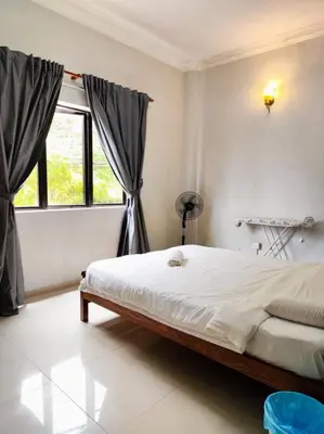a bedroom with a large bed and a window at Bukit Cottage - bungalow style in Tanah Rata