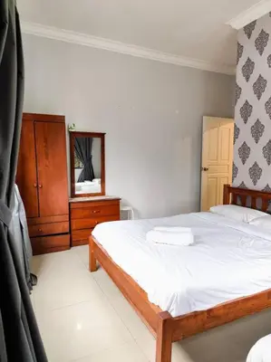 a bedroom with a bed and a dresser and a mirror at Bukit Cottage - bungalow style in Tanah Rata