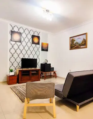 a living room with a couch and a tv at Bukit Cottage - bungalow style in Tanah Rata