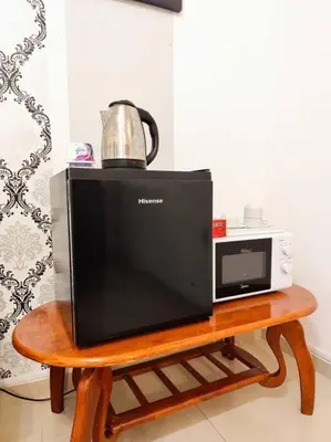 a television and a microwave on a wooden table at Bukit Cottage - bungalow style in Tanah Rata