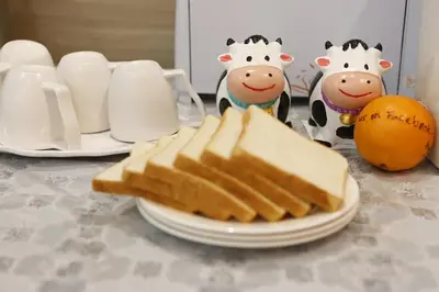 a plate with slices of bread on a table with cows statues at Big Orange Hotel Sungai Petani in Sungai Petani