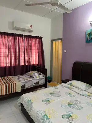 a bedroom with two beds and a window at Station 18 Homestay 3R3B in Ipoh