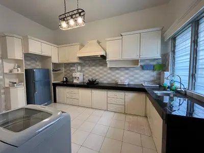 a large kitchen with a sink and a refrigerator at Station 18 Homestay 3R3B in Ipoh