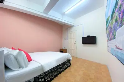 a bedroom with a bed and a tv on a wall at B Hotel Penang in George Town