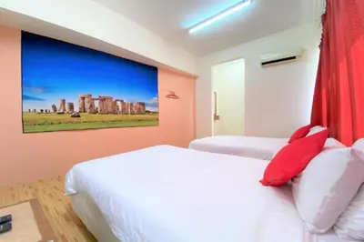 two beds in a room with a painting on the wall at B Hotel Penang in George Town