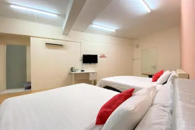 a room with two beds with red pillows at B Hotel Penang in George Town
