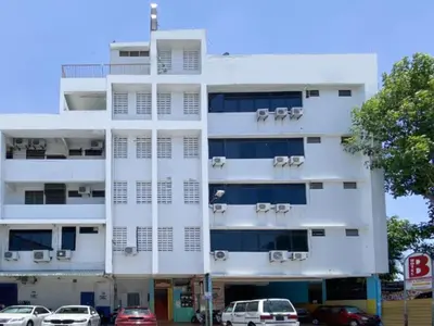 a white building with cars parked in front of it at B Hotel Penang in George Town