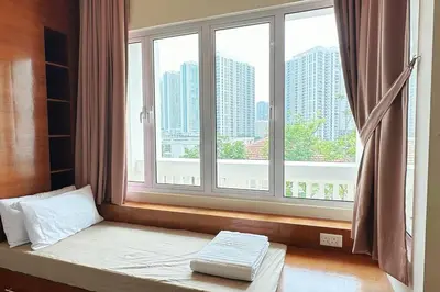 a bed in a room with a large window at Straits Quay Highest Floor PoolView Suite in Tanjong Tokong