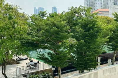 a group of trees in front of a building at Straits Quay Highest Floor PoolView Suite in Tanjong Tokong