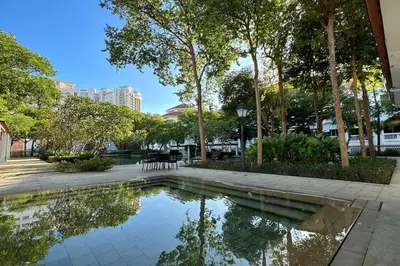 a pool of water in a park with trees at Straits Quay Highest Floor PoolView Suite in Tanjong Tokong