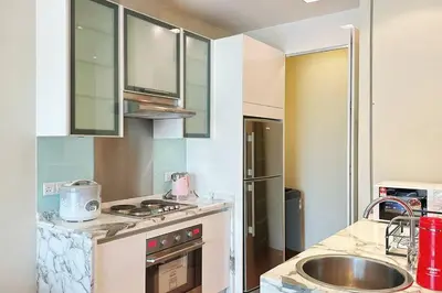 a kitchen with a sink and a stove top oven at Straits Quay Highest Floor PoolView Suite in Tanjong Tokong