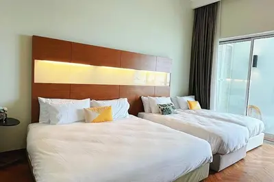 two beds in a hotel room with white sheets at Straits Quay Highest Floor Infinity SeaView Suite in Tanjong Tokong