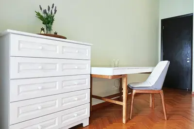 a bedroom with a white dresser and a desk with a chair at Straits Quay Highest Floor Infinity SeaView Suite in Tanjong Tokong