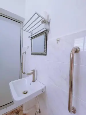 a white bathroom with a sink and a mirror at Gioia DeGarden in Taiping