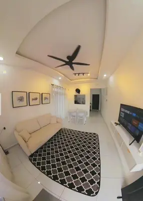 a living room with a couch and a ceiling fan at Homestay Dataran Tikam Batu in Sungai Petani