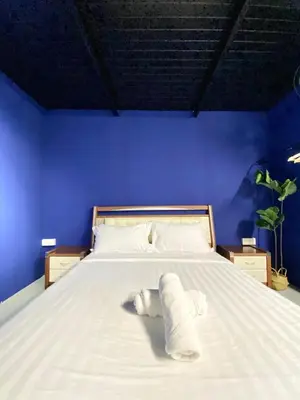 a bed in a blue room with a towel on it at Bayu Bayu Hotel by Soft Loft in Tanjung Bungah