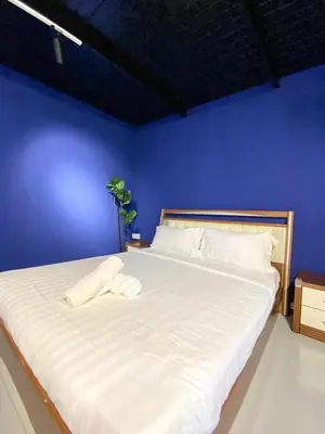 a blue bedroom with a large bed with white sheets at Bayu Bayu Hotel by Soft Loft in Tanjung Bungah