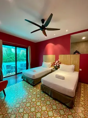 two beds in a room with a ceiling fan at Bayu Bayu Hotel by Soft Loft in Tanjung Bungah