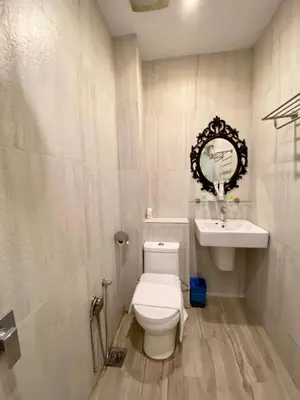 a white bathroom with a toilet and a sink at Bayu Bayu Hotel by Soft Loft in Tanjung Bungah