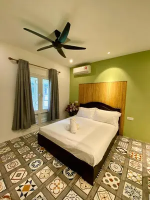 a bedroom with a bed with a ceiling fan at Bayu Bayu Hotel by Soft Loft in Tanjung Bungah